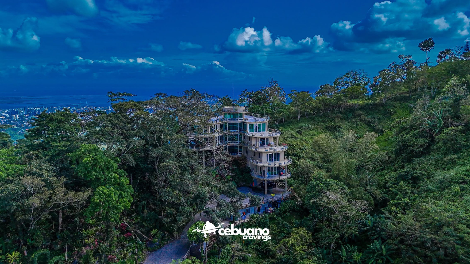 The Soul Sierra estate at dusk with Cebu City lights along the coastline below